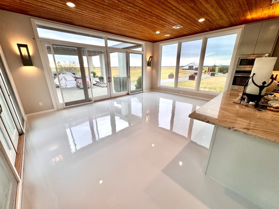 Glossy white epoxy floor in an open living and kitchen area