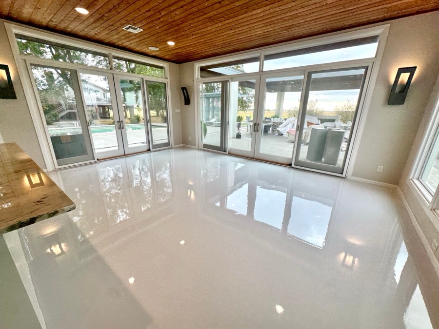 White epoxy floor in a sunroom with pool views