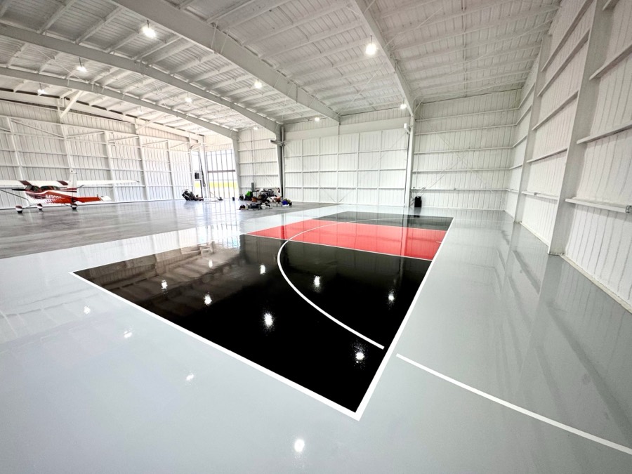 Black and red court painted on a gray hangar floor