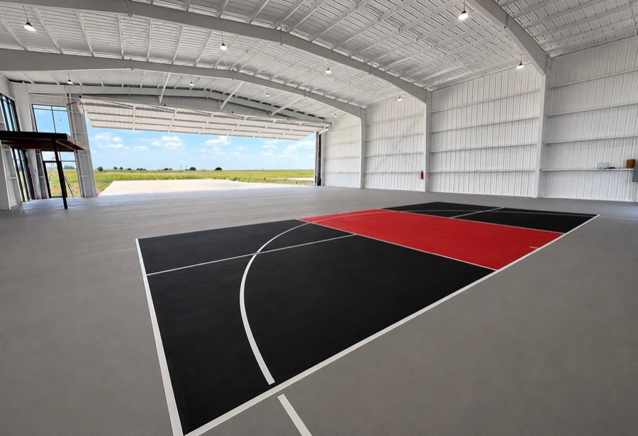 Black and red court in a hangar with the door open